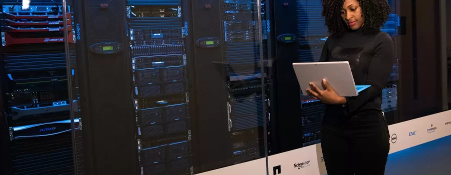 software engineer standing beside server racks