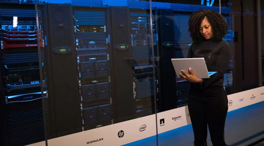 software engineer standing beside server racks